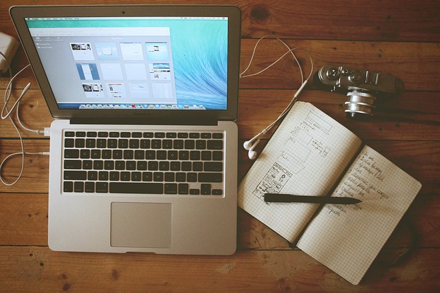laptop a sešit v domácí kanceláři