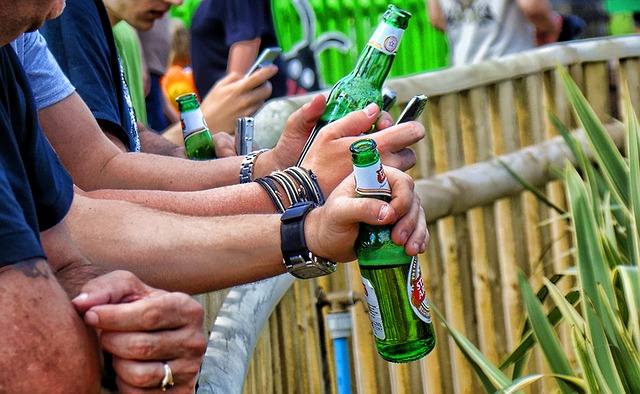 muži drží v rukou lahve piva